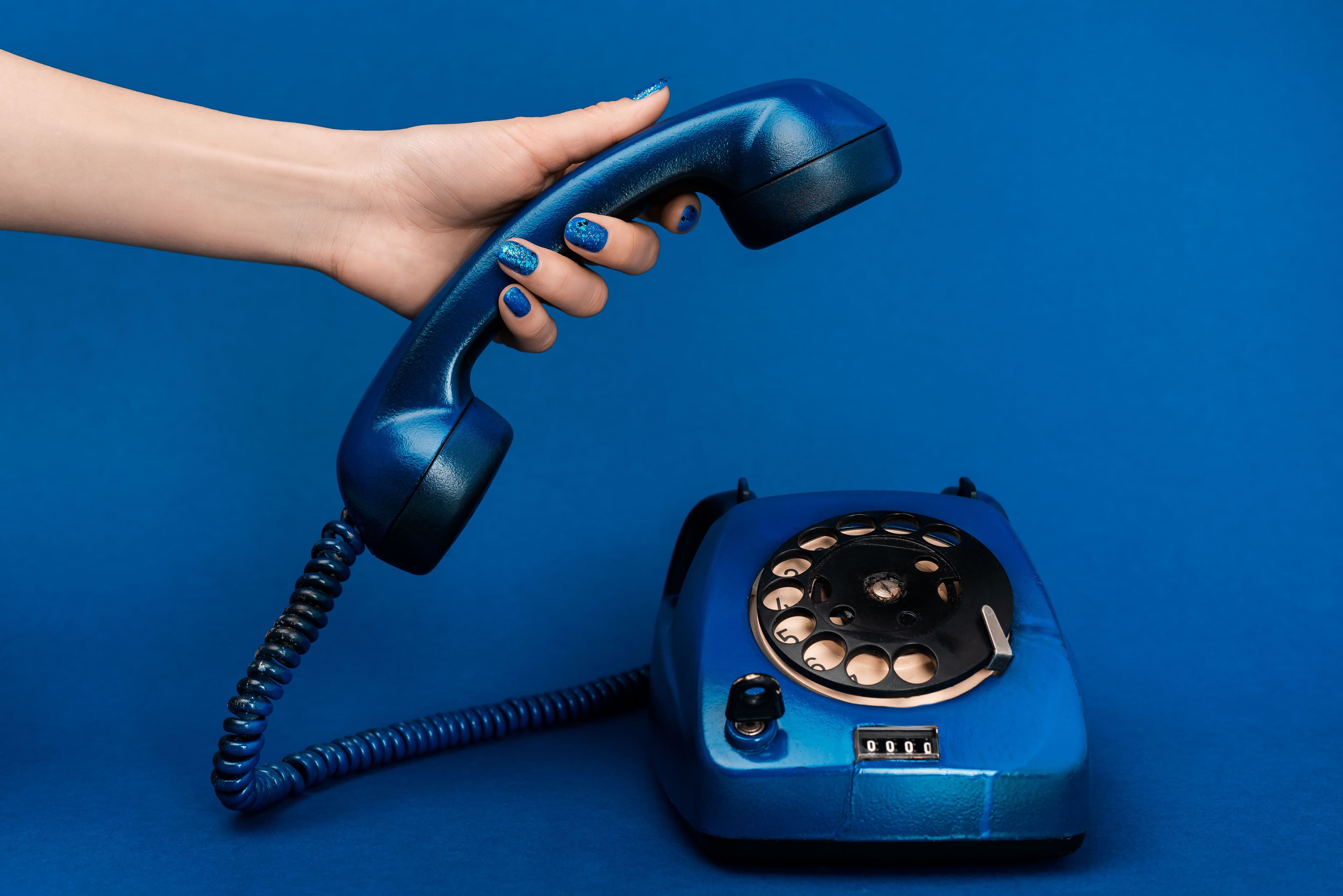 cropped-view-of-woman-holding-handset-on-blue-back-2024-11-17-14-01-14-utc.jpg